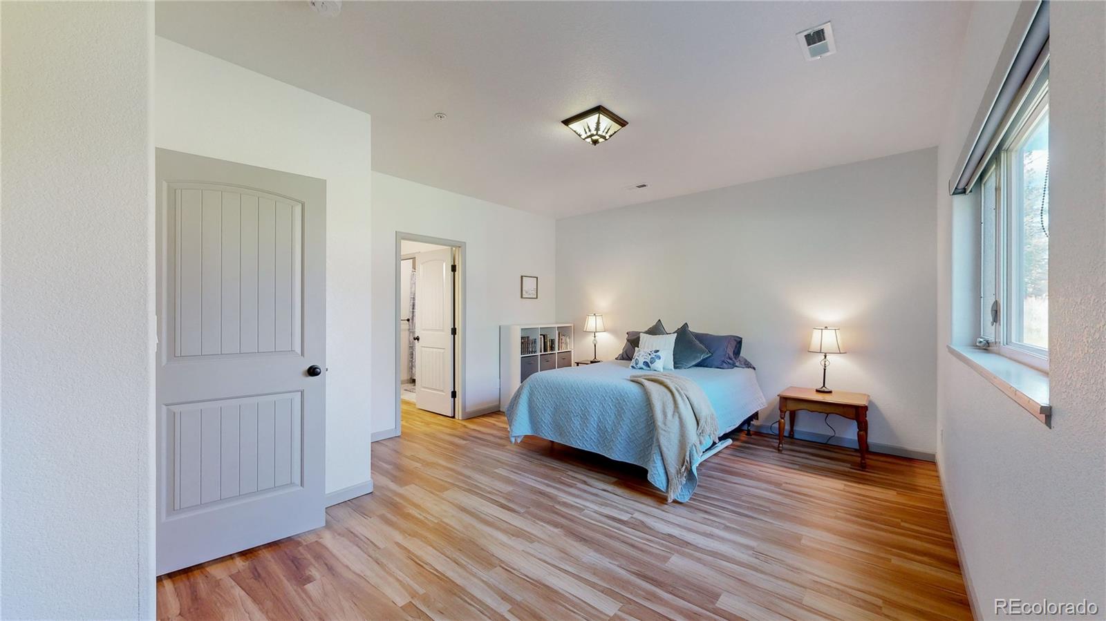 230 Mohawk Trail Pine, CO 80470 - Photo 19 of 39 a bedroom with a bed and wooden floor