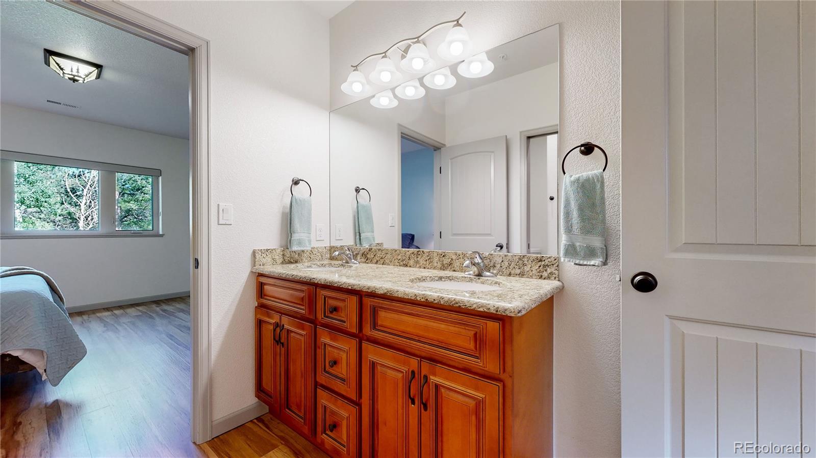 230 Mohawk Trail Pine, CO 80470 - Photo 21 of 39 a bathroom with a granite countertop sink a large mirror and a shower