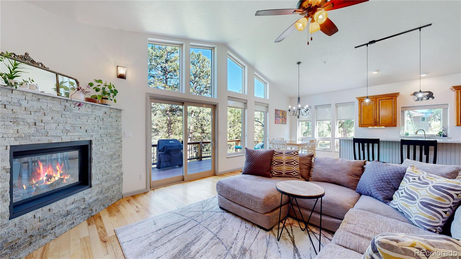 230 Mohawk Trail Pine, CO 80470 - Photo 3 of 39 a living room with furniture a fireplace and a ceiling fan