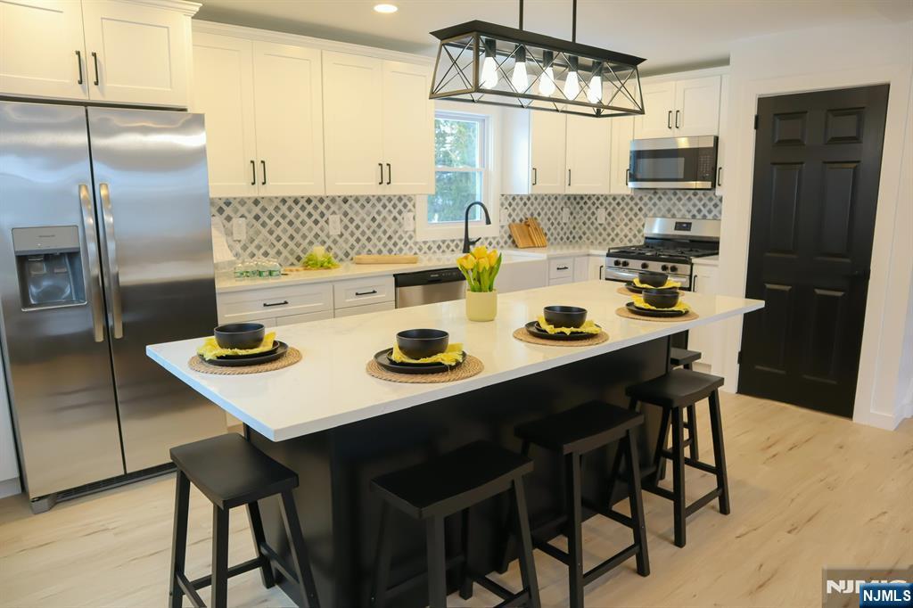 78 Poplar Avenue Little Ferry, NJ 07643 - Photo 1 of 23 a kitchen with stainless steel appliances granite countertop a dining table chairs and refrigerator