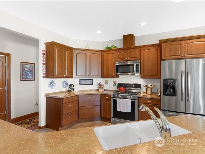 285 West Birnie Slough Road Cathlamet, WA 98612 - Photo 12 of 40 a kitchen with stainless steel appliances granite countertop a stove top oven a sink dishwasher and a refrigerator