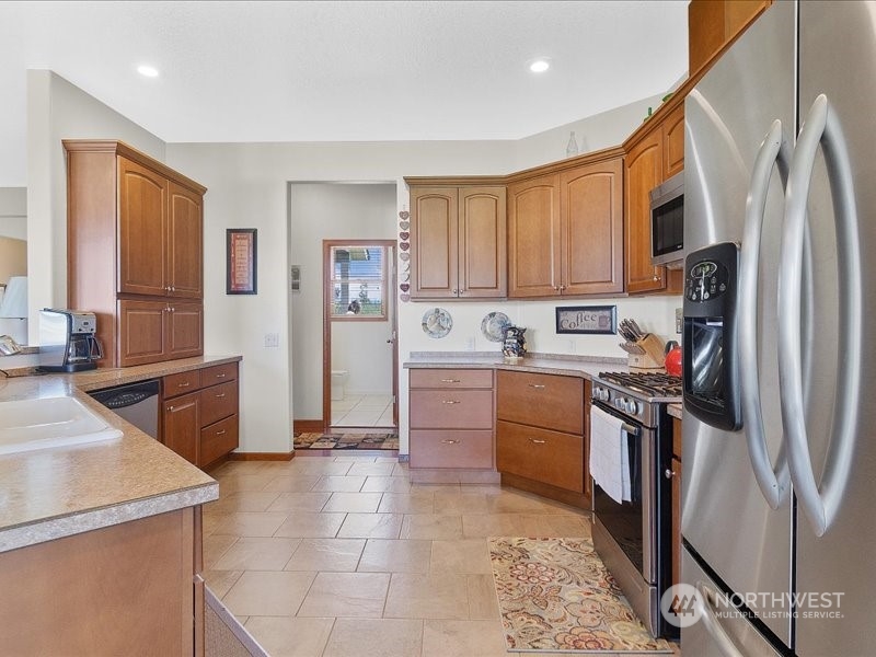 285 West Birnie Slough Road Cathlamet, WA 98612 - Photo 13 of 40 a kitchen with stainless steel appliances granite countertop a refrigerator a stove top oven a sink and dishwasher