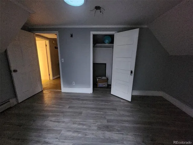 an empty room with wooden floor and closet