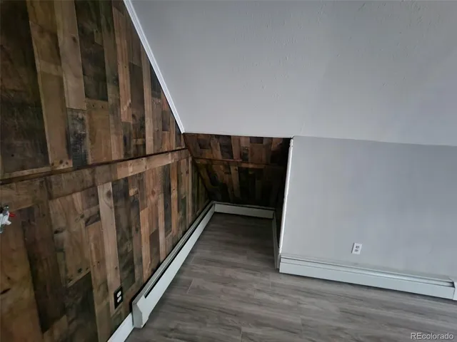 a view of staircase with wooden floor and white walls