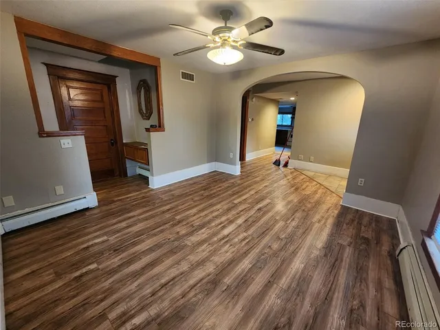 a view of a room with wooden floor and a ceiling fan