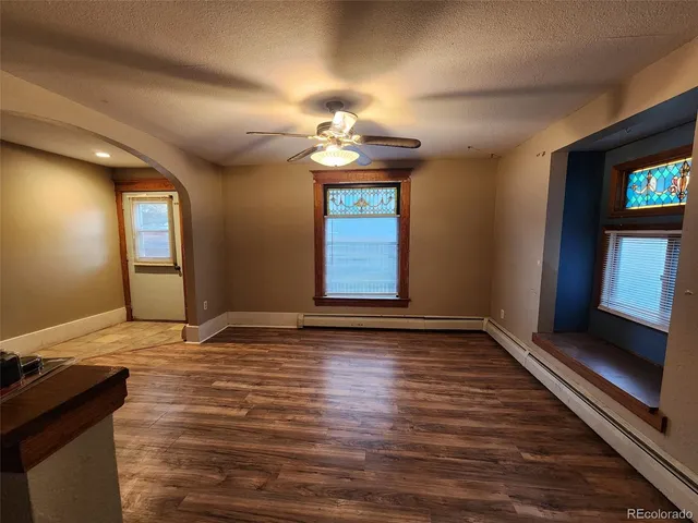 a view of an empty room with window and wooden floor