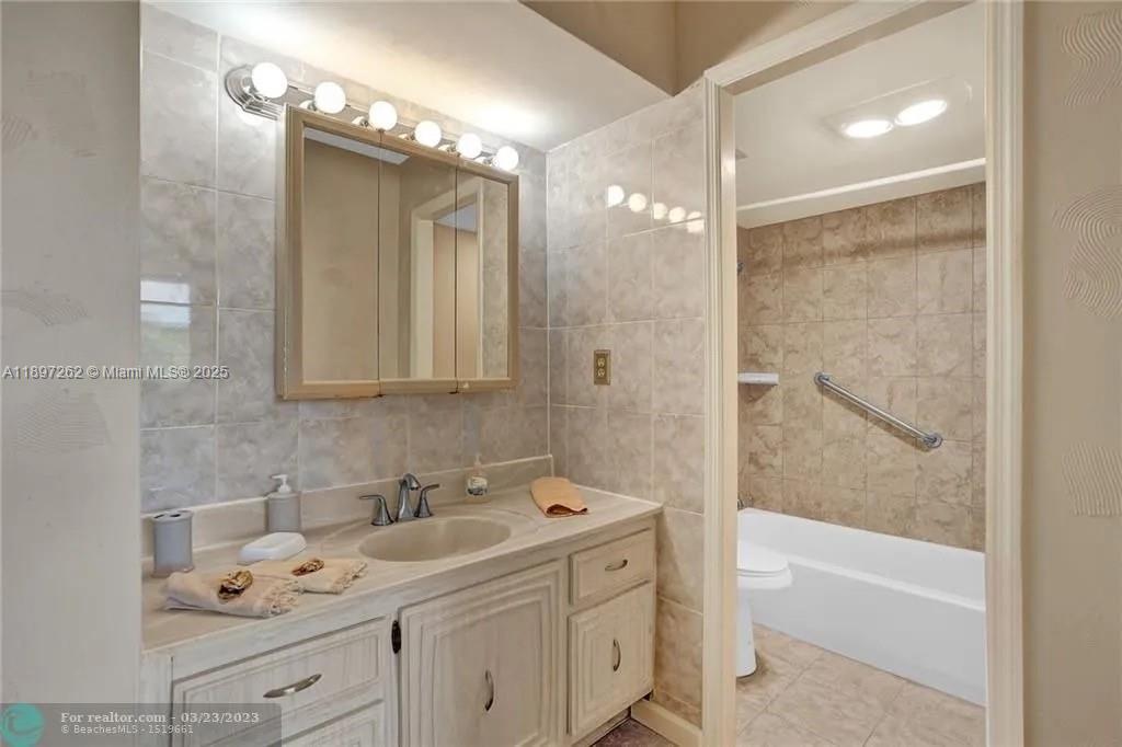 7051 Environ Boulevard, Unit 337 Lauderhill, FL 33319 - Photo 4 of 15 a bathroom with a double vanity sink mirror and bathtub