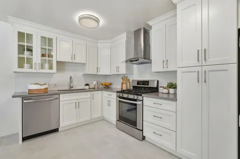 a kitchen with granite countertop white cabinets and white appliances
