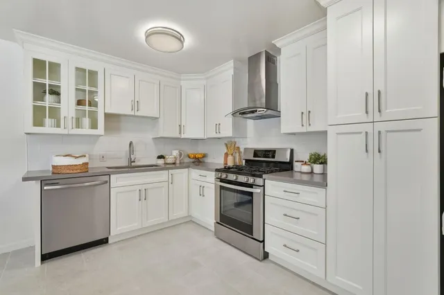 a kitchen with granite countertop white cabinets and white appliances