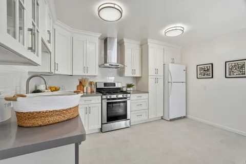 a kitchen with stainless steel appliances granite countertop a stove a sink and a refrigerator