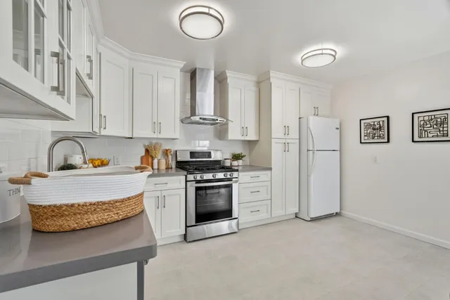 a kitchen with stainless steel appliances granite countertop a stove a sink and a refrigerator