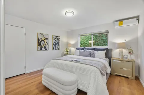 a bedroom with a bed and a painting on the wall