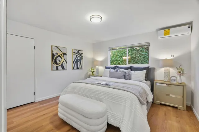 a bedroom with a bed and a painting on the wall