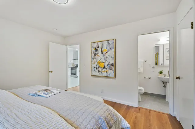 a bedroom with a bed and a painting on the wall