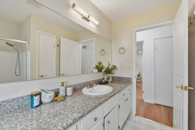 a bathroom with a granite countertop sink and a mirror