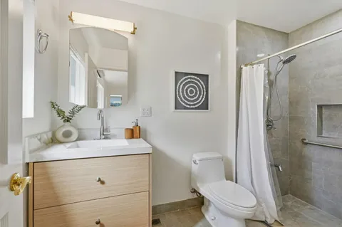 a bathroom with a sink mirror vanity and toilet