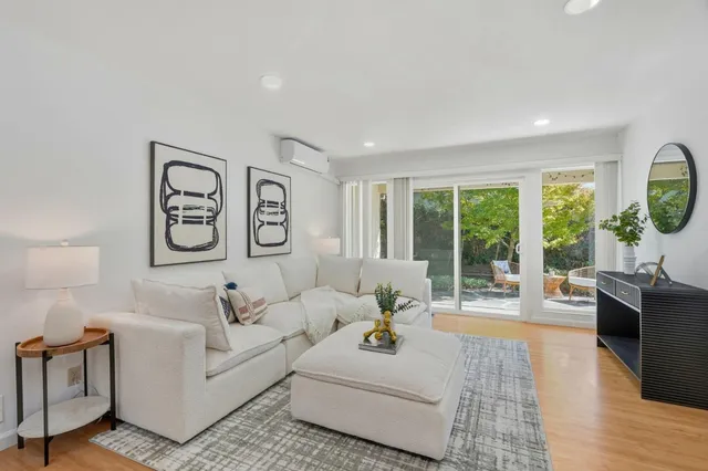 a living room with furniture a large window and a flat screen tv