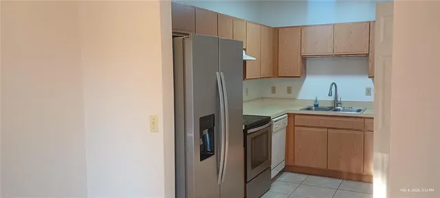 a kitchen with a refrigerator sink and cabinets