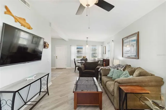 a living room with furniture a dining table and a chandelier