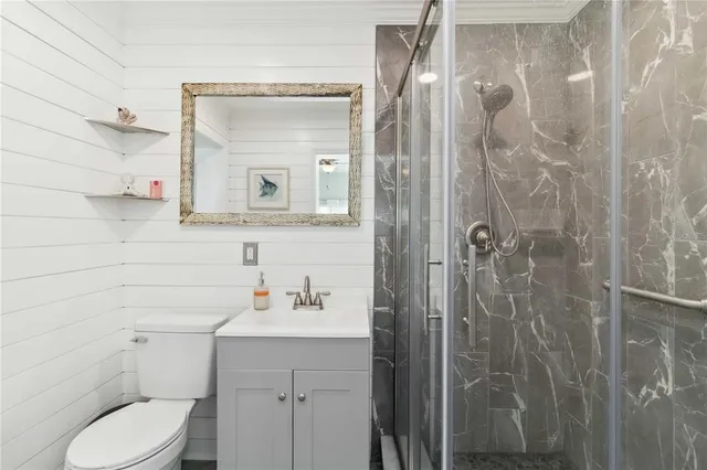 a bathroom with a shower a sink a toilet and mirror