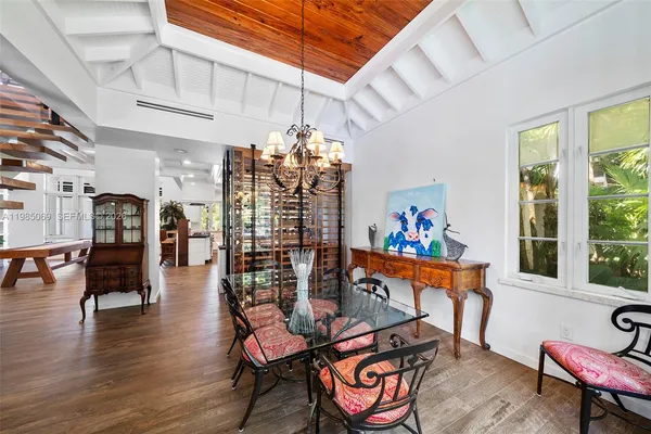 a room with stainless steel appliances lots of wooden furniture and wooden floors