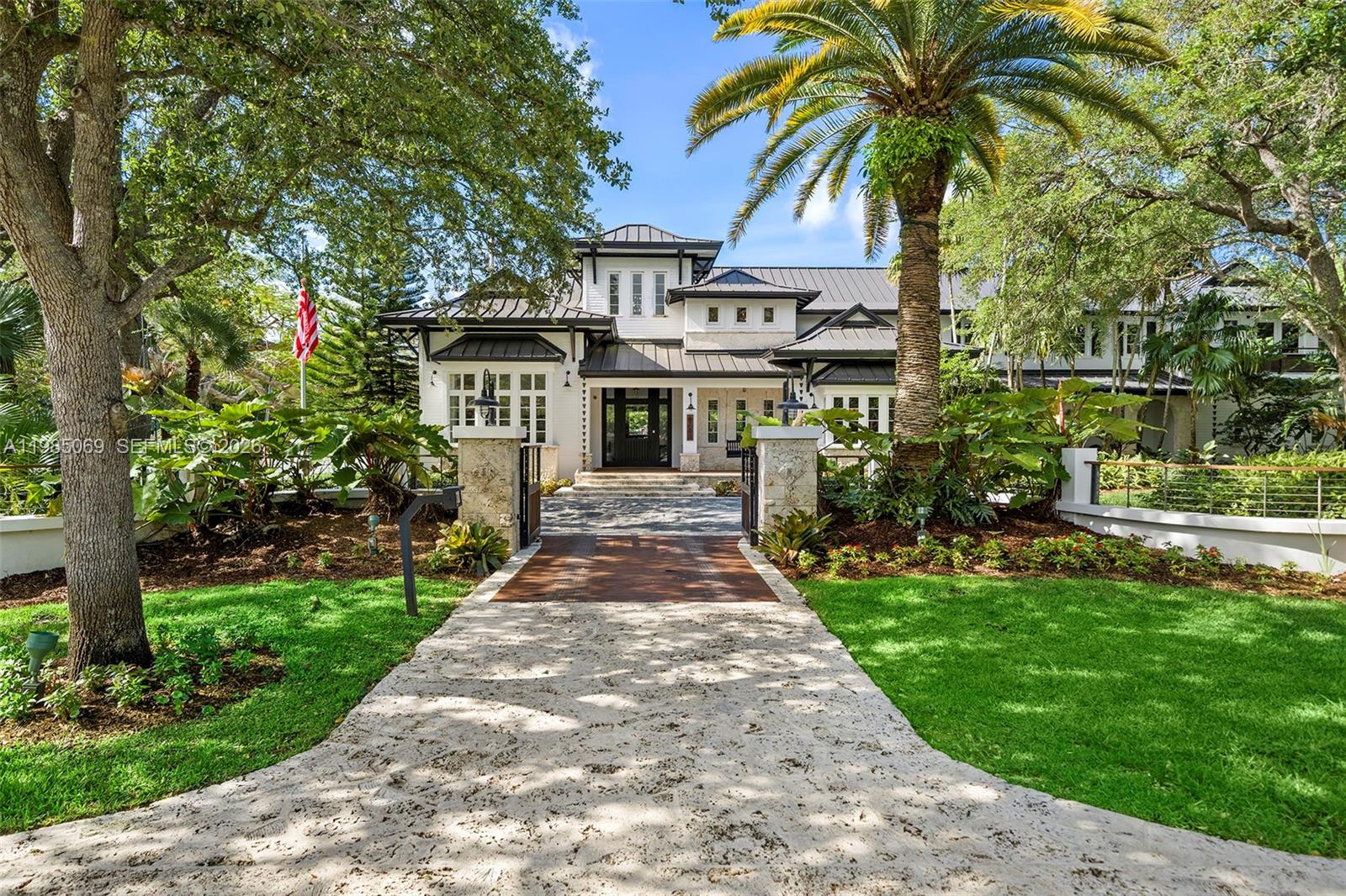 6700 Southwest 132nd Street Pinecrest, FL 33156 - Photo 2 of 99 a front view of a house with a garden