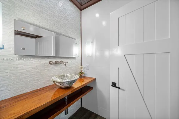 a bathroom with a sink shower and a mirror