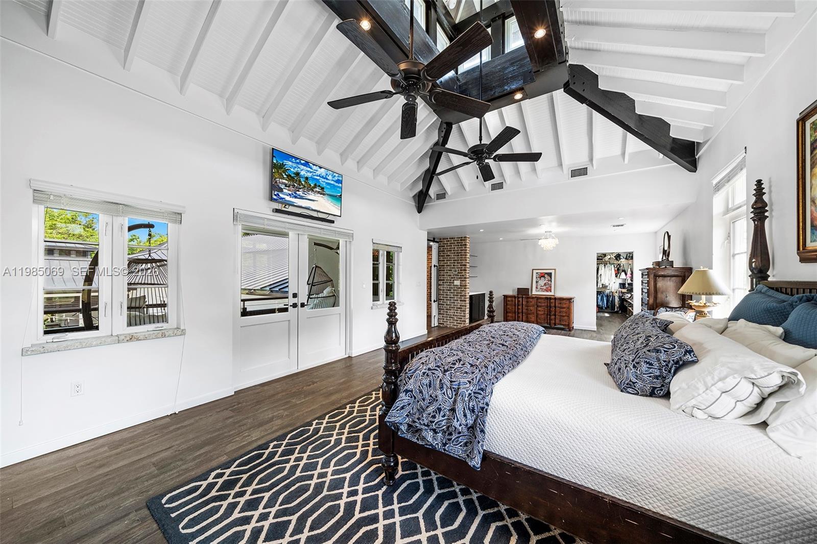 6700 Southwest 132nd Street Pinecrest, FL 33156 - Photo 64 of 99 a bedroom with furniture ceiling fan and a wooden floor