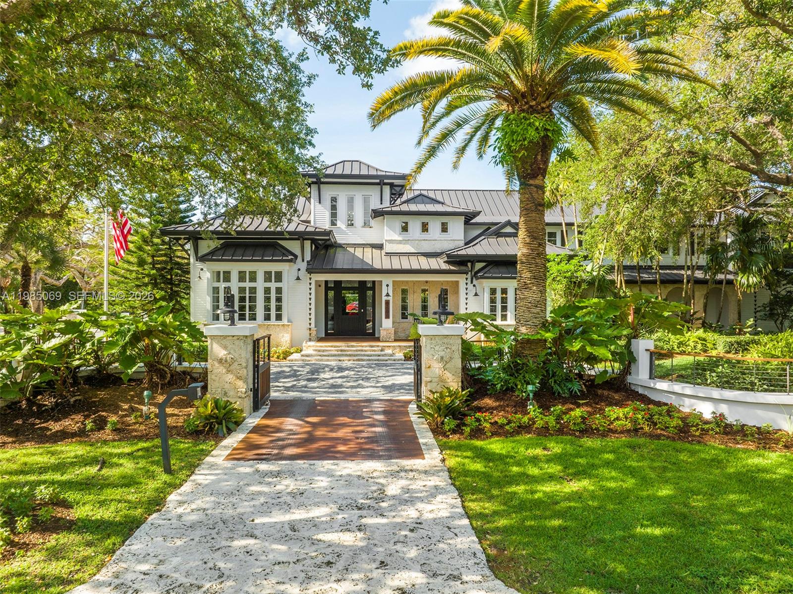 6700 Southwest 132nd Street Pinecrest, FL 33156 - Photo 87 of 99 a front view of a house with a garden and trees