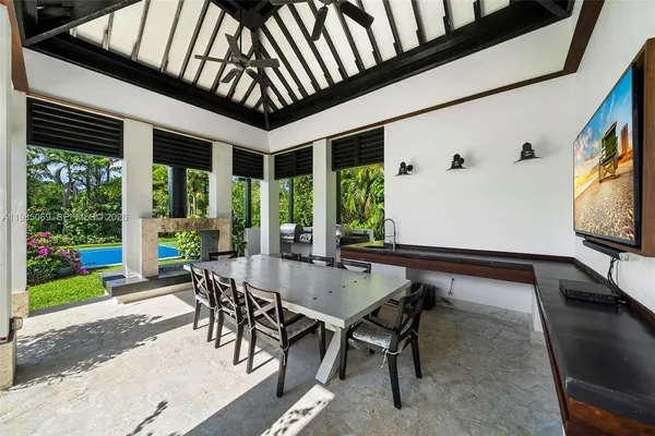 a kitchen with stainless steel appliances kitchen island granite countertop a table chairs and white cabinets