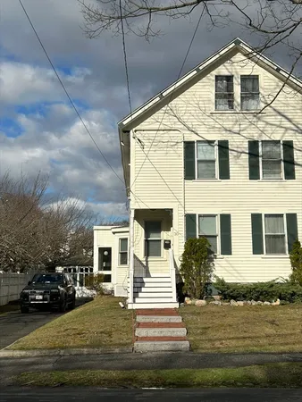 a view of a white house with a yard