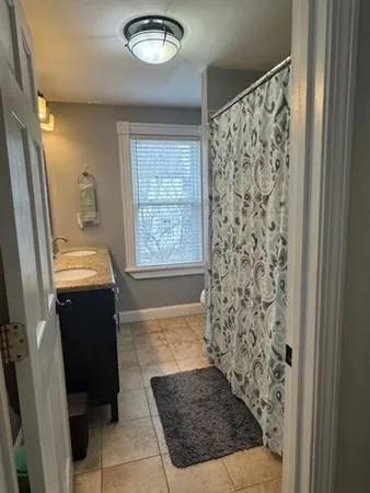 a view of a hallway to a livingroom with furniture and windows