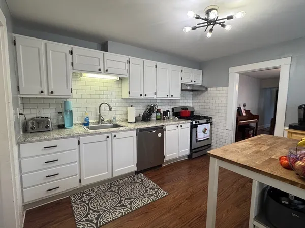 a kitchen with a stove a sink and cabinets