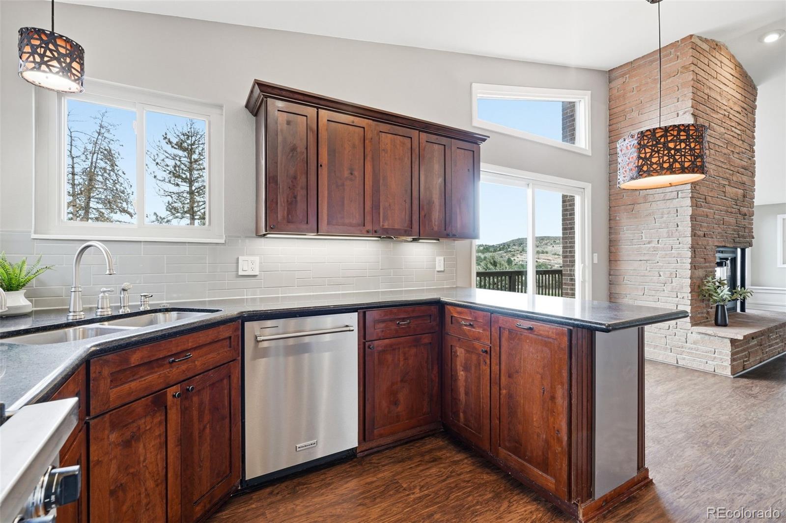 15743 Wedge Way Morrison, CO 80465 - Photo 20 of 48 a kitchen with stainless steel appliances granite countertop a sink and wooden cabinets