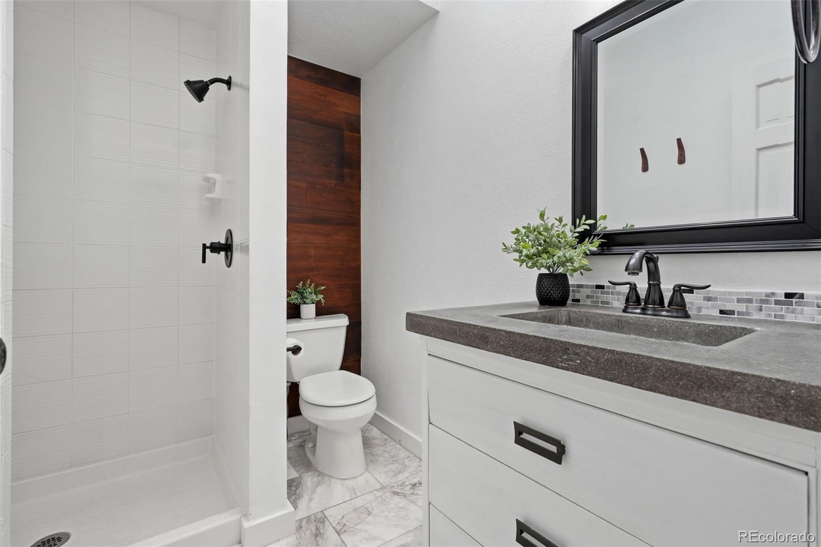 15743 Wedge Way Morrison, CO 80465 - Photo 26 of 48 a bathroom with a granite countertop sink toilet and shower