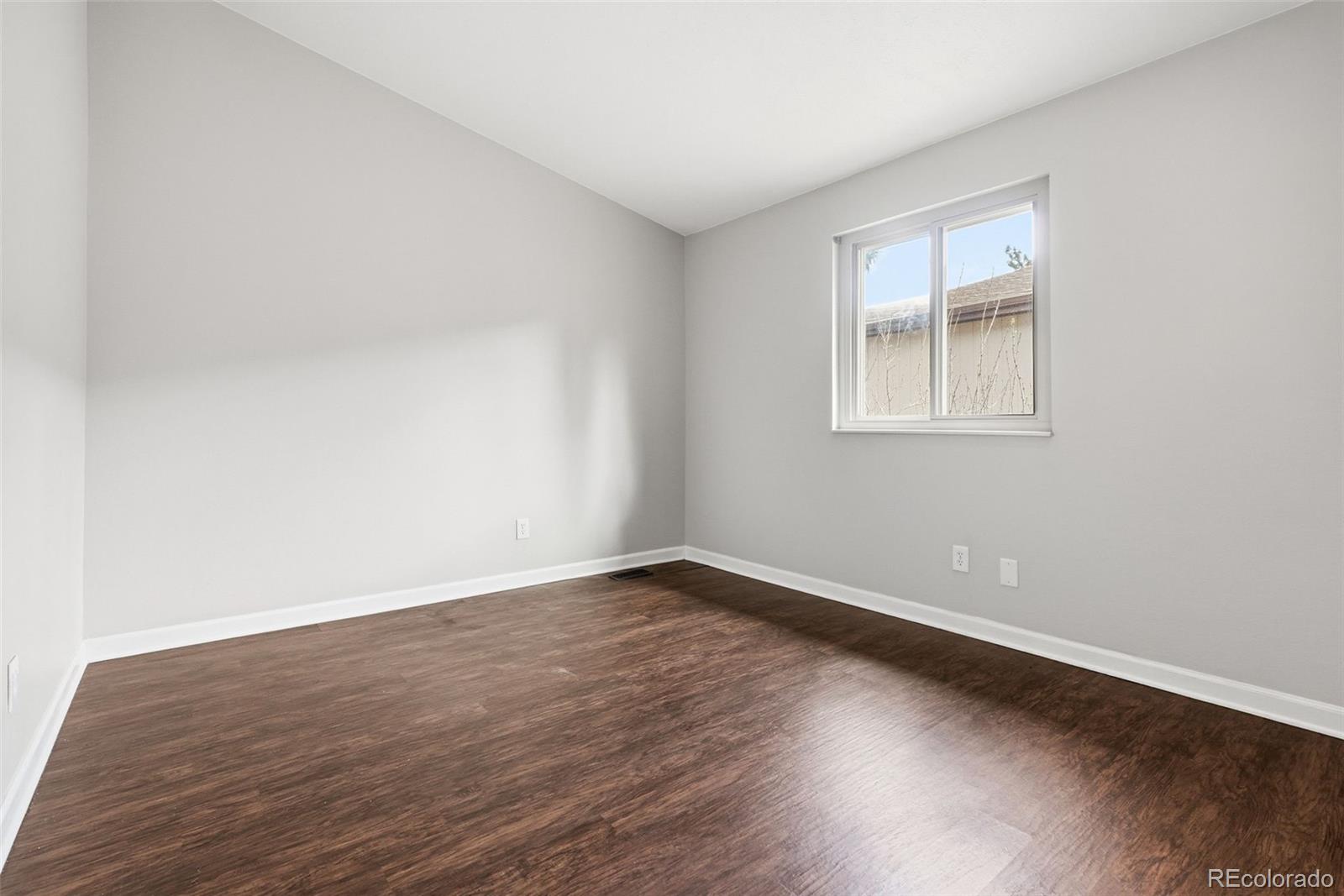 15743 Wedge Way Morrison, CO 80465 - Photo 27 of 48 an empty room with wooden floor and windows