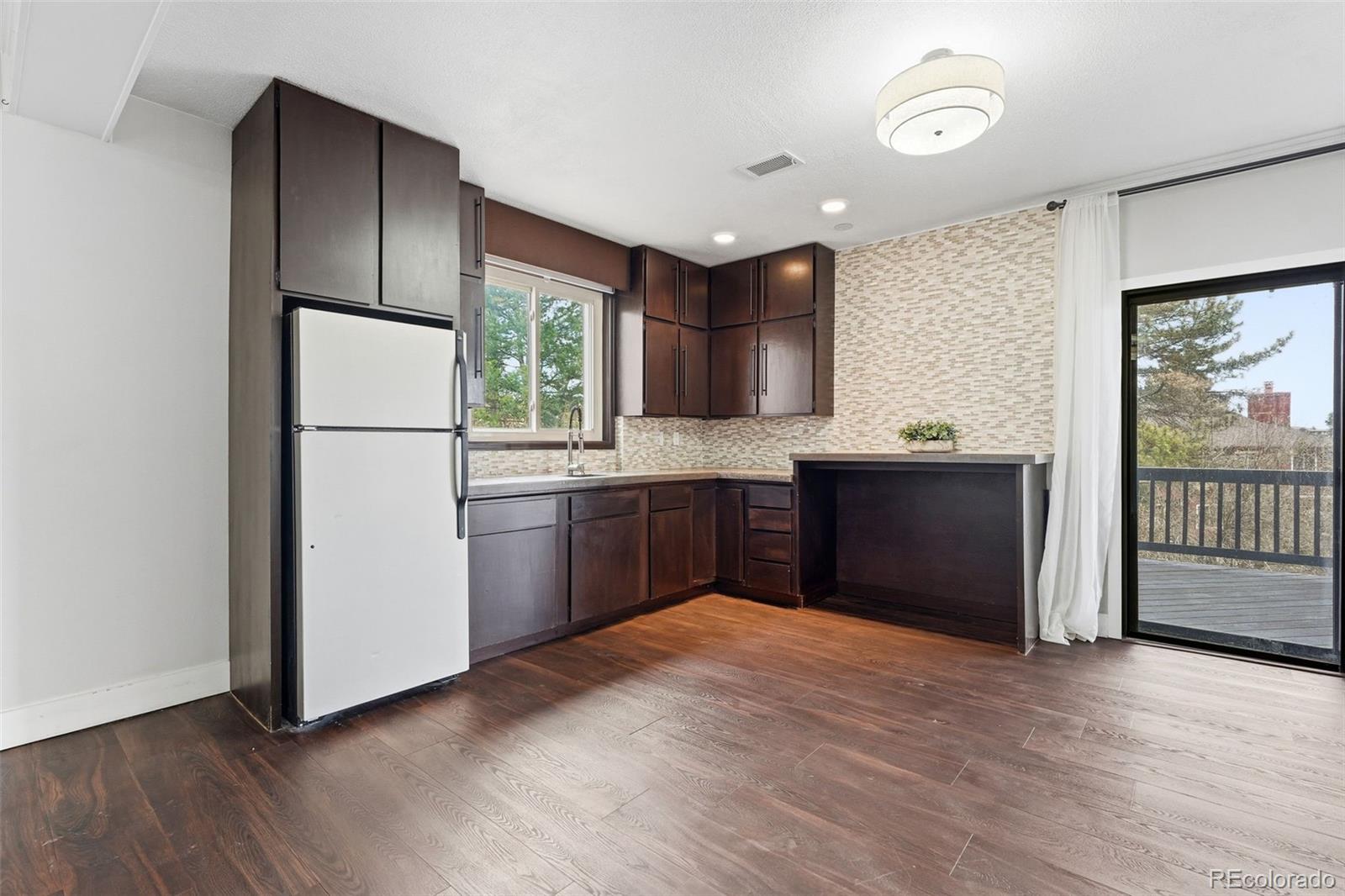 15743 Wedge Way Morrison, CO 80465 - Photo 32 of 48 a kitchen with kitchen island a counter top space wooden floor and stainless steel appliances