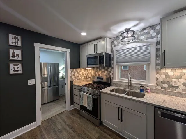 a kitchen with stainless steel appliances granite countertop a refrigerator and a stove top oven