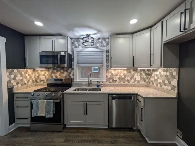 a kitchen with stainless steel appliances granite countertop a sink stove and refrigerator