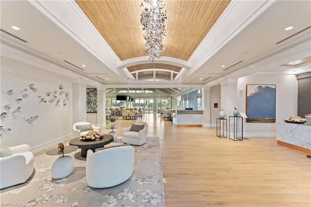 a living room with patio furniture and a chandelier