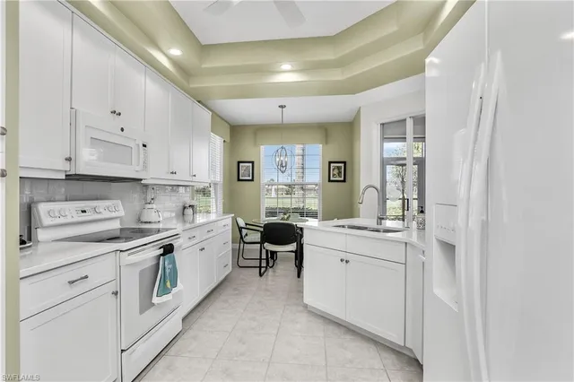 a large white kitchen with cabinets