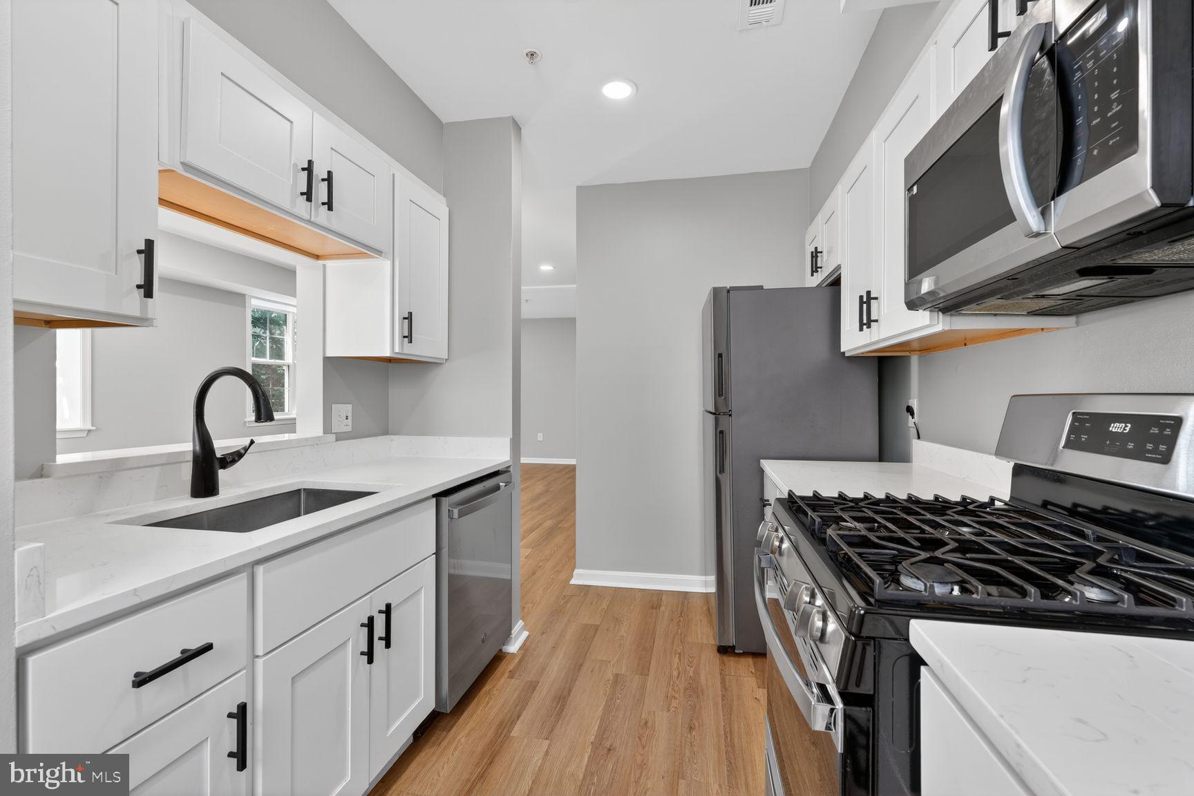 1008 Rittenhouse Street Northwest, Unit 15 Washington, DC 20011 - Photo 11 of 39 a kitchen with stainless steel appliances granite countertop a sink stove and cabinets