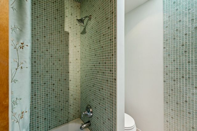 a room with stainless steel appliances kitchen island granite countertop a table chairs and a refrigerator