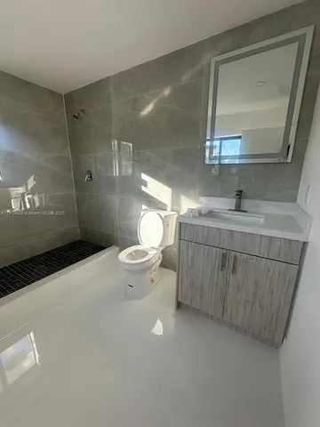 a bathroom with a sink a toilet and mirror