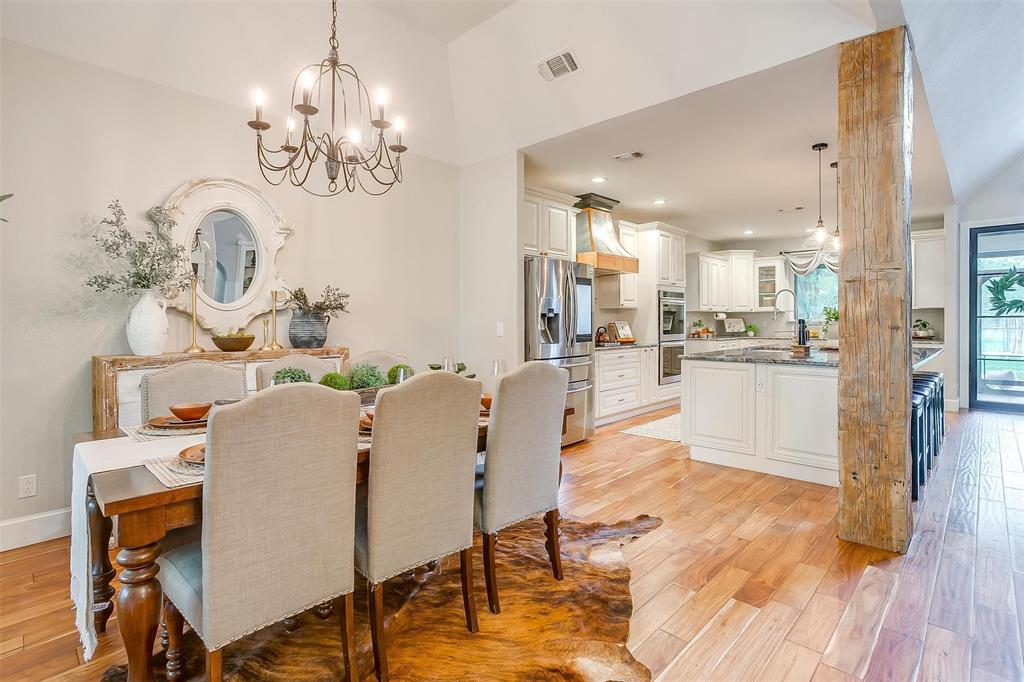 4962 Farm To Market 113 Millsap, TX 76066 - Photo 32 of 36 a living room with kitchen island dining table wooden floor and a chandelier
