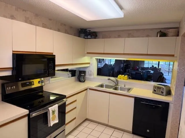 a kitchen with stainless steel appliances a stove a sink and a microwave