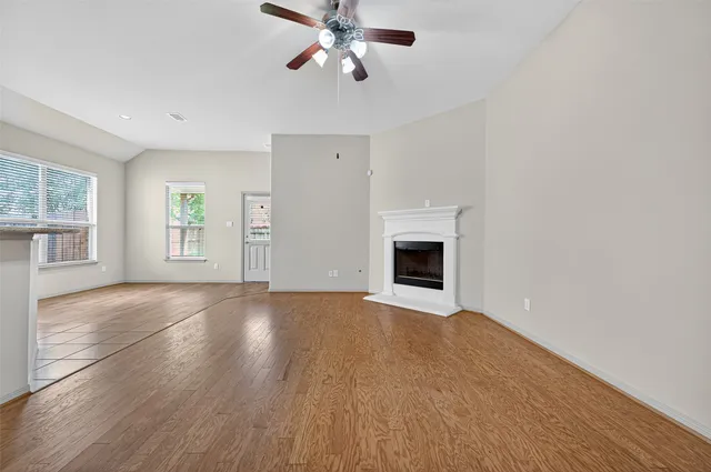 an empty room with windows and fireplace