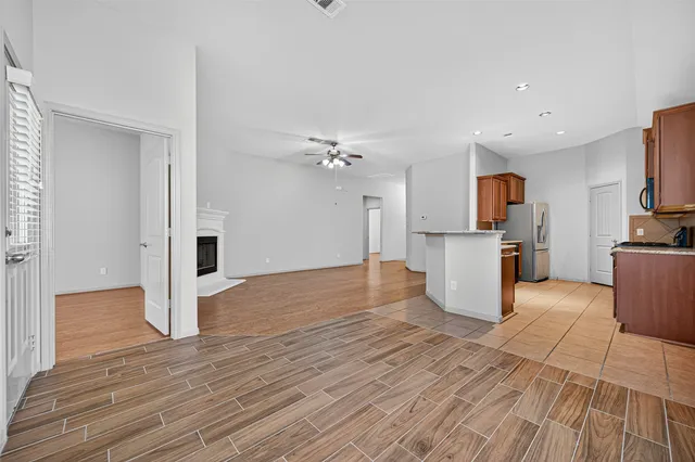 a view of a kitchen with wooden floor and a refrigerator