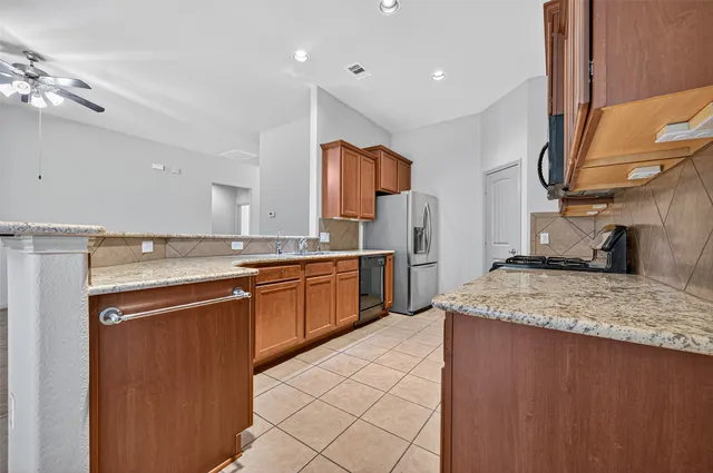 a kitchen with stainless steel appliances granite countertop a sink stove and refrigerator