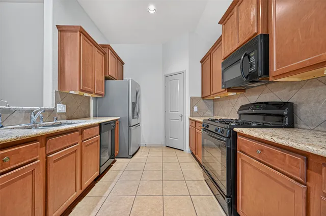 a kitchen with stainless steel appliances granite countertop a stove top oven a sink dishwasher and a microwave oven on the blue kitchen countertops